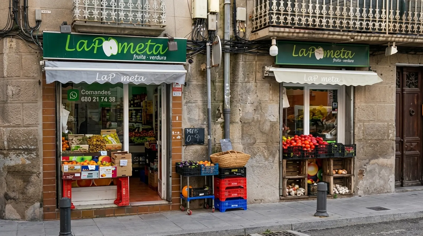 La façana de La Pometa al Carrer del Pont de Torelló, amb les caixes de fruita a la porta